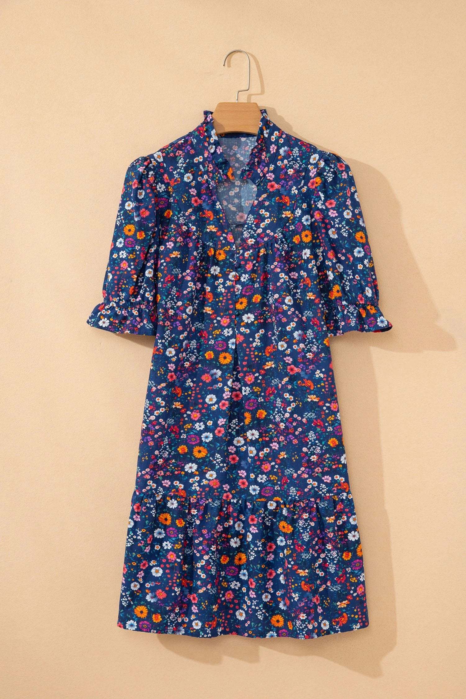 Woman wearing navy wild daisy floral split-neck puff-sleeve mini dress