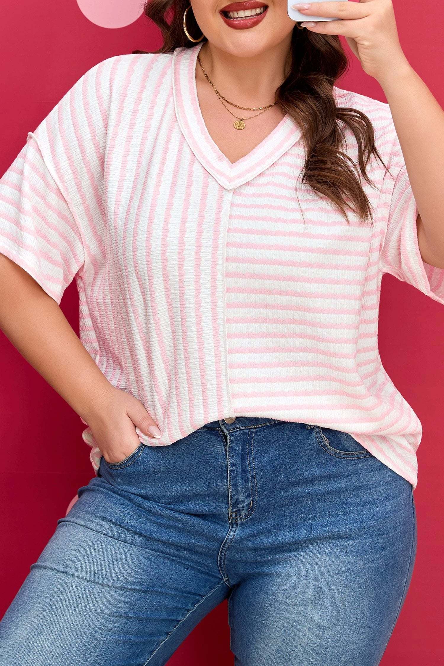 Plus size pink stripe V-neck tee with exposed seam detailing on a model