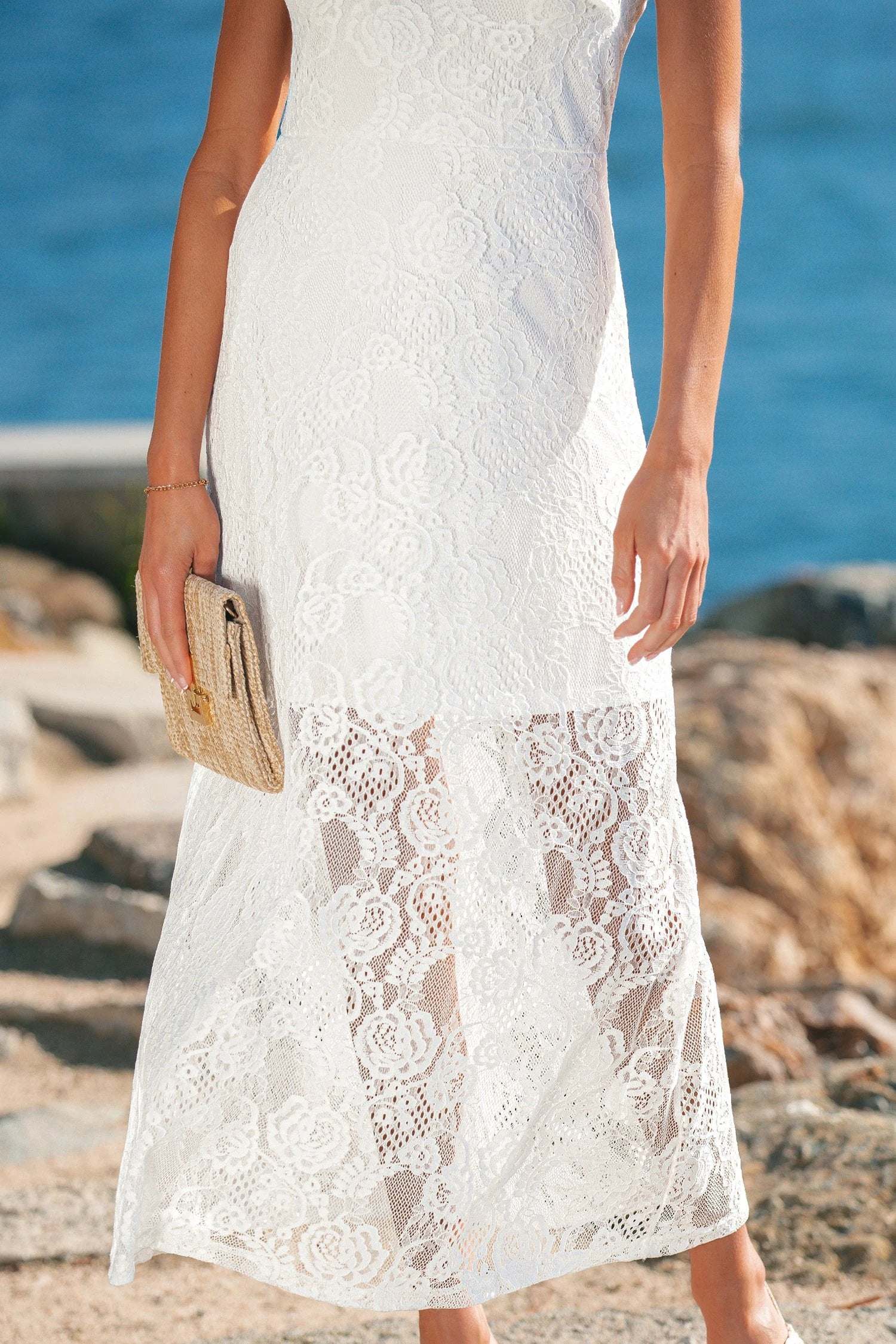Woman wearing a floral lace overlay maxi dress with spaghetti straps and scalloped edges