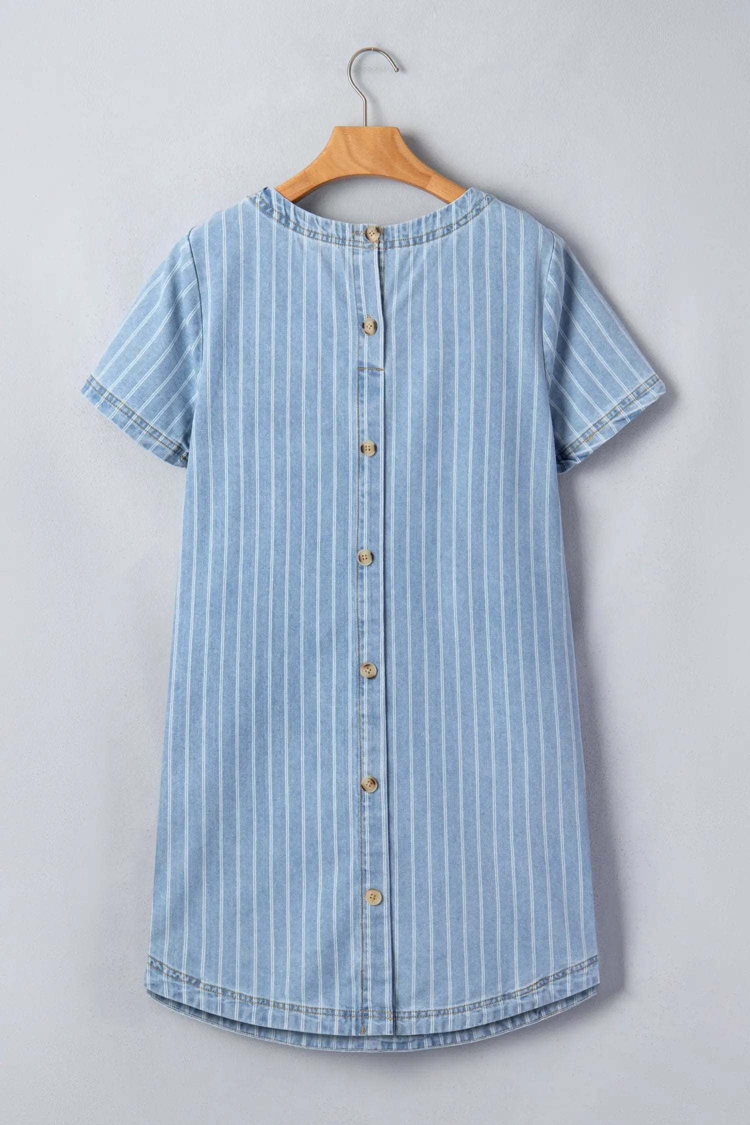 Woman wearing effortless chic stripe denim mini dress with buttoned back and vertical stripes