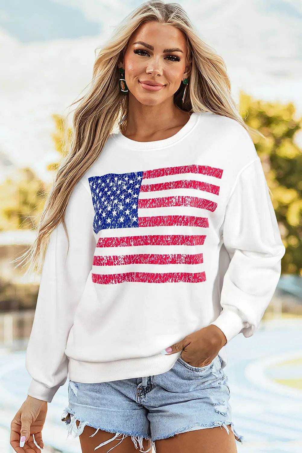 Oversized white sweatshirt with distressed American flag graphic and drop-shoulder design