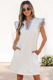 Woman wearing a striped sleeveless dress with split neck and ruffle trim outdoors