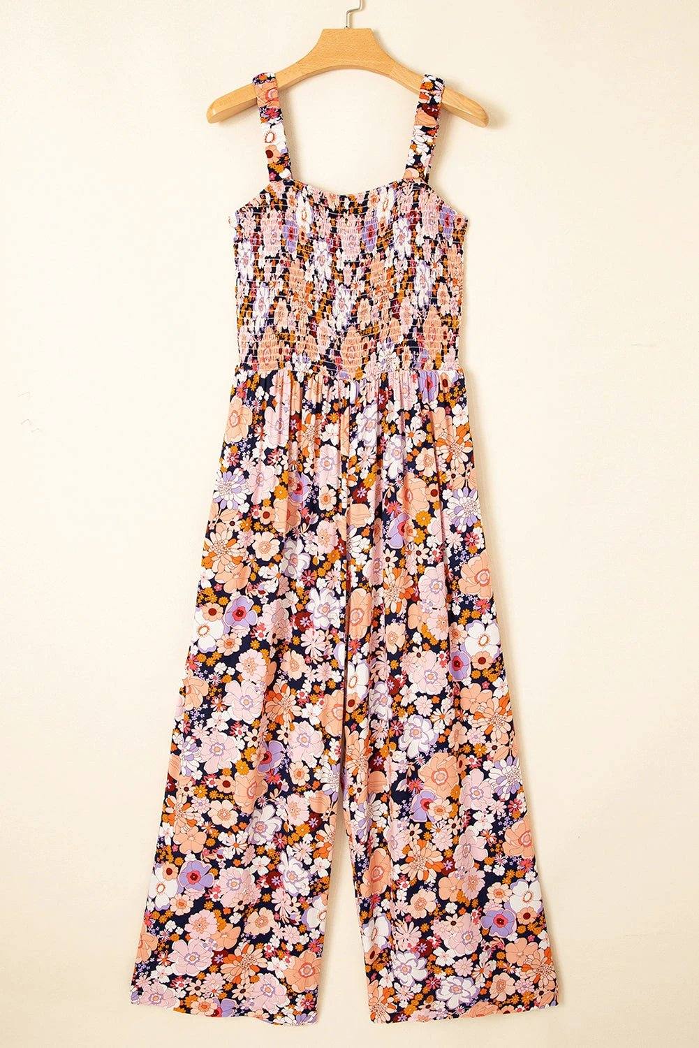 Boho Chic floral smocked square-neck jumpsuit with wide-leg silhouette on dark backdrop