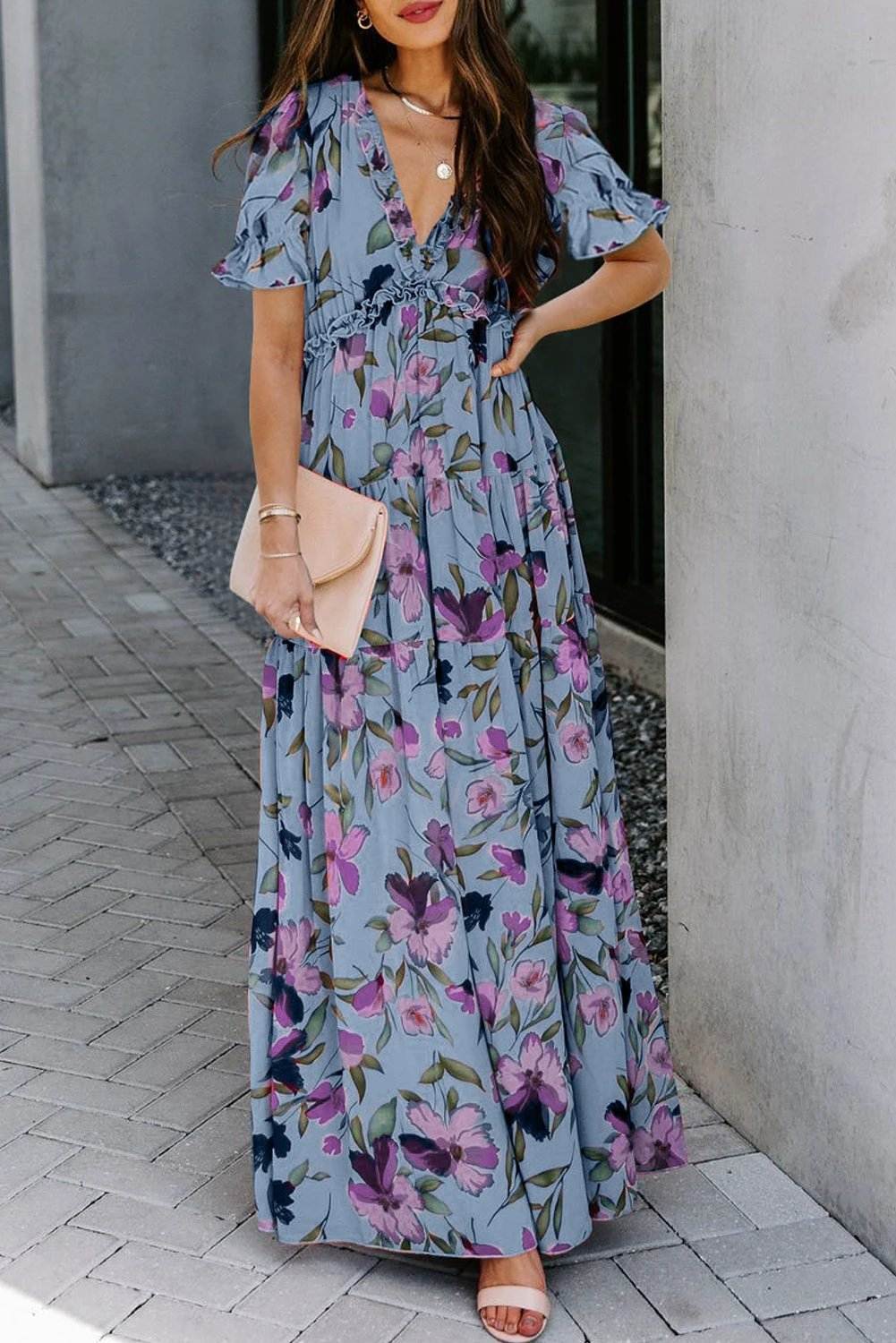 Woman wearing a sky blue floral print maxi dress with frilled V-neck and short flutter sleeves