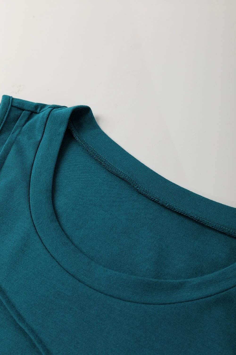 Sapphire-green round neck tank top with diagonal stitching detail and relaxed fit.