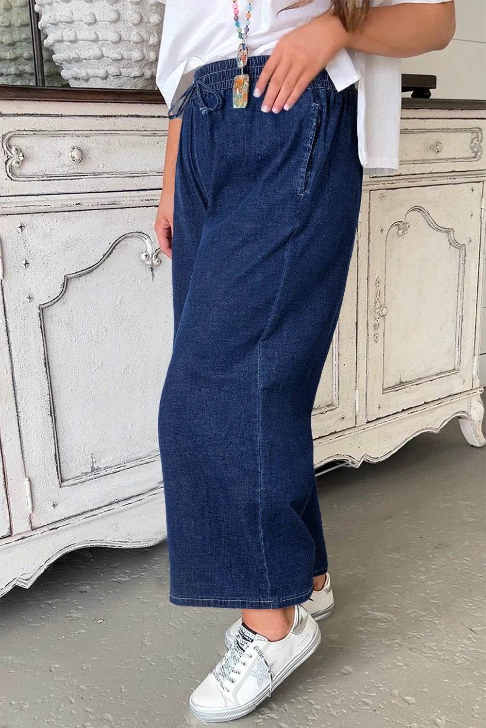 Plus size woman wearing indigo drawstring high waist wide leg jeans