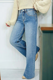 Woman wearing distressed tummy-control high-rise jeans with raw hem and casual white sneakers