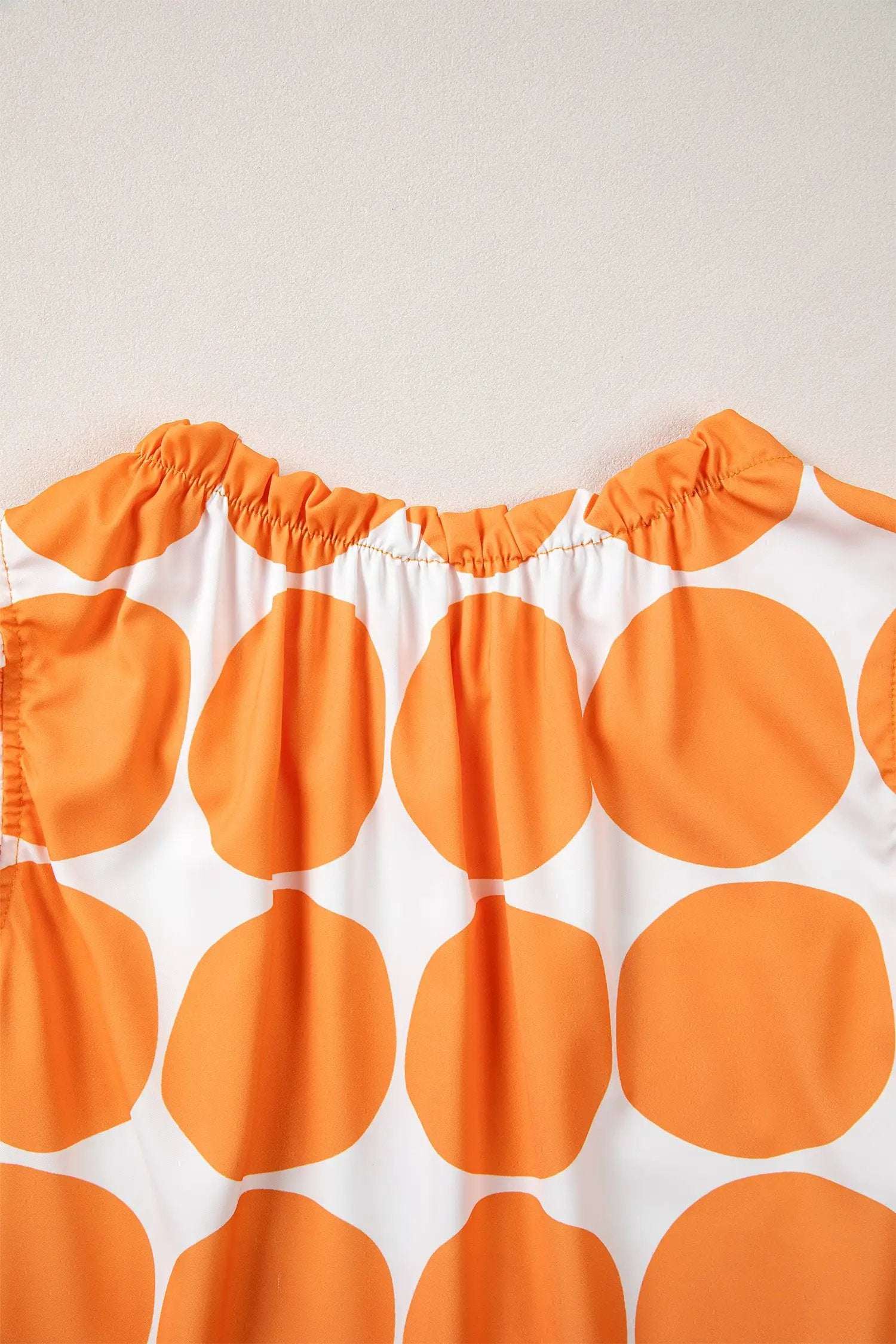 Blue and white polka dot tank top with frilled round neckline and sleeveless design