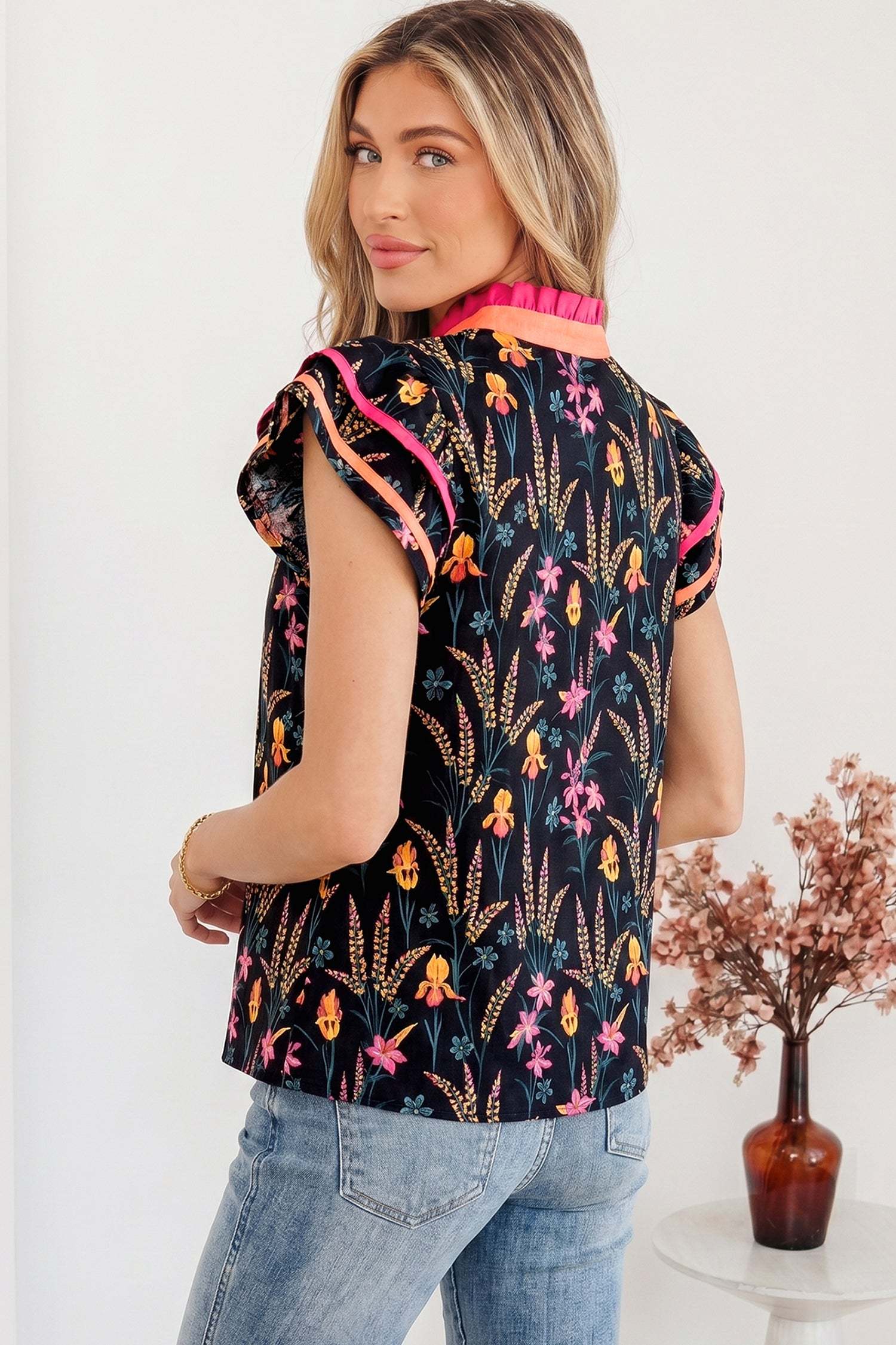 Black floral print tiered blouse with short flutter sleeves and contrast trim neckline