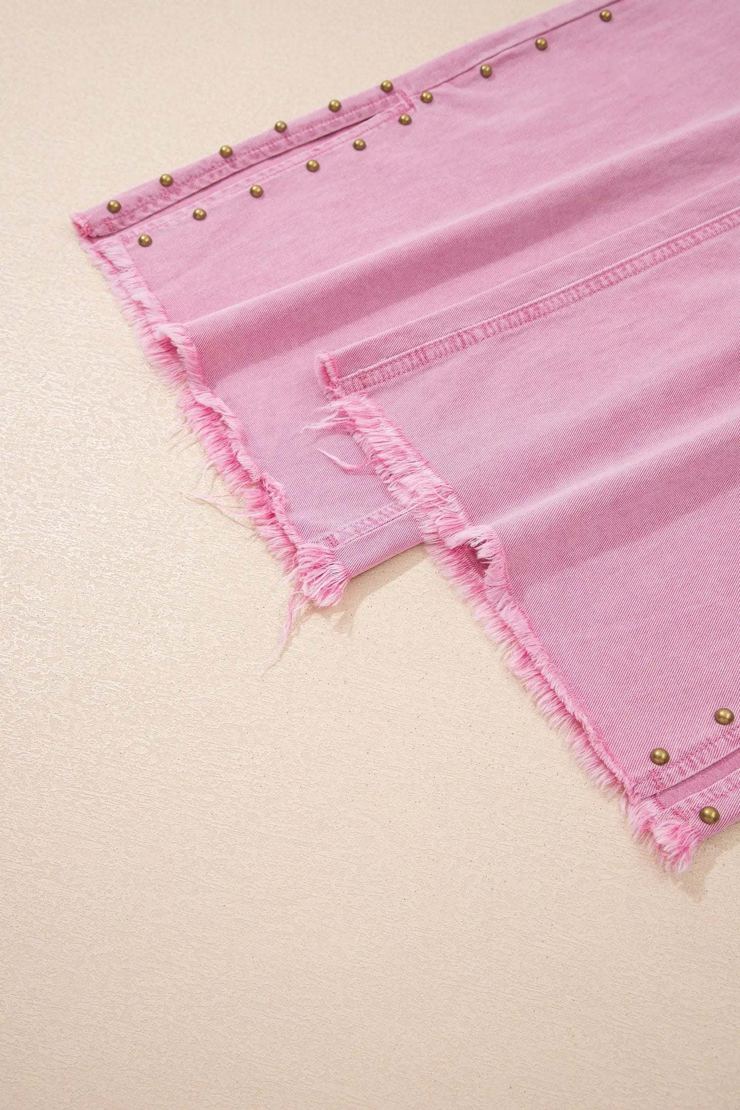 Pink high-rise wide-leg jeans with beaded side detail and split hem on model