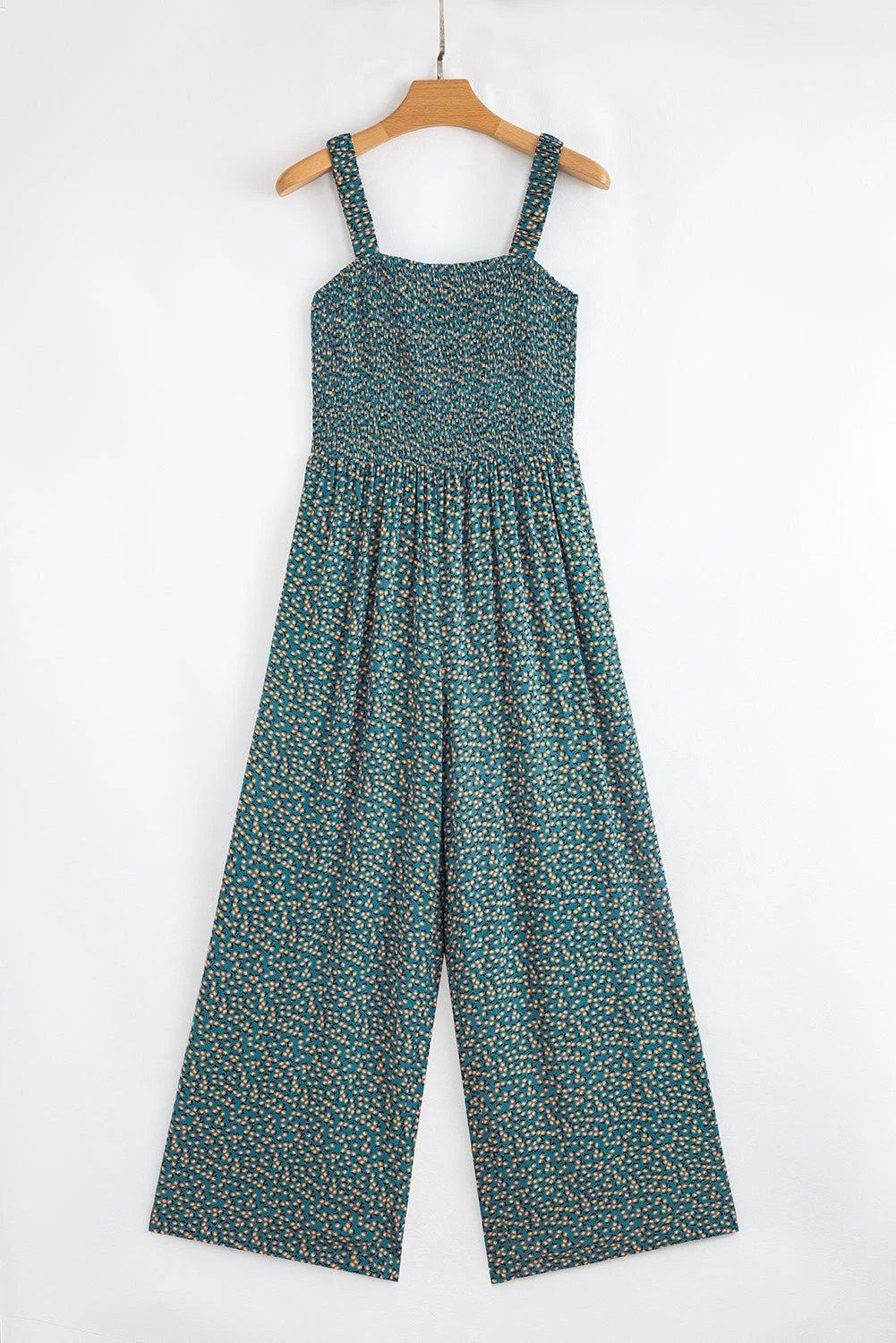 Boho chic floral smocked jumpsuit with square neckline and wide-leg silhouette on dark background