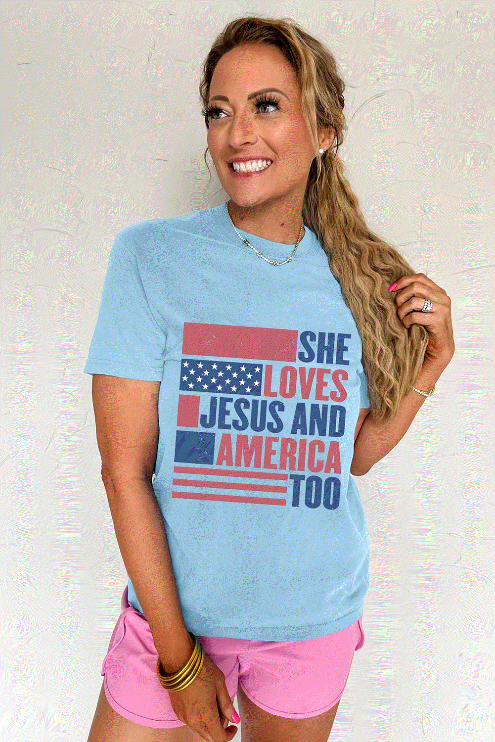 Light blue women's tee with "She Loves Jesus And America Too" patriotic flag graphic