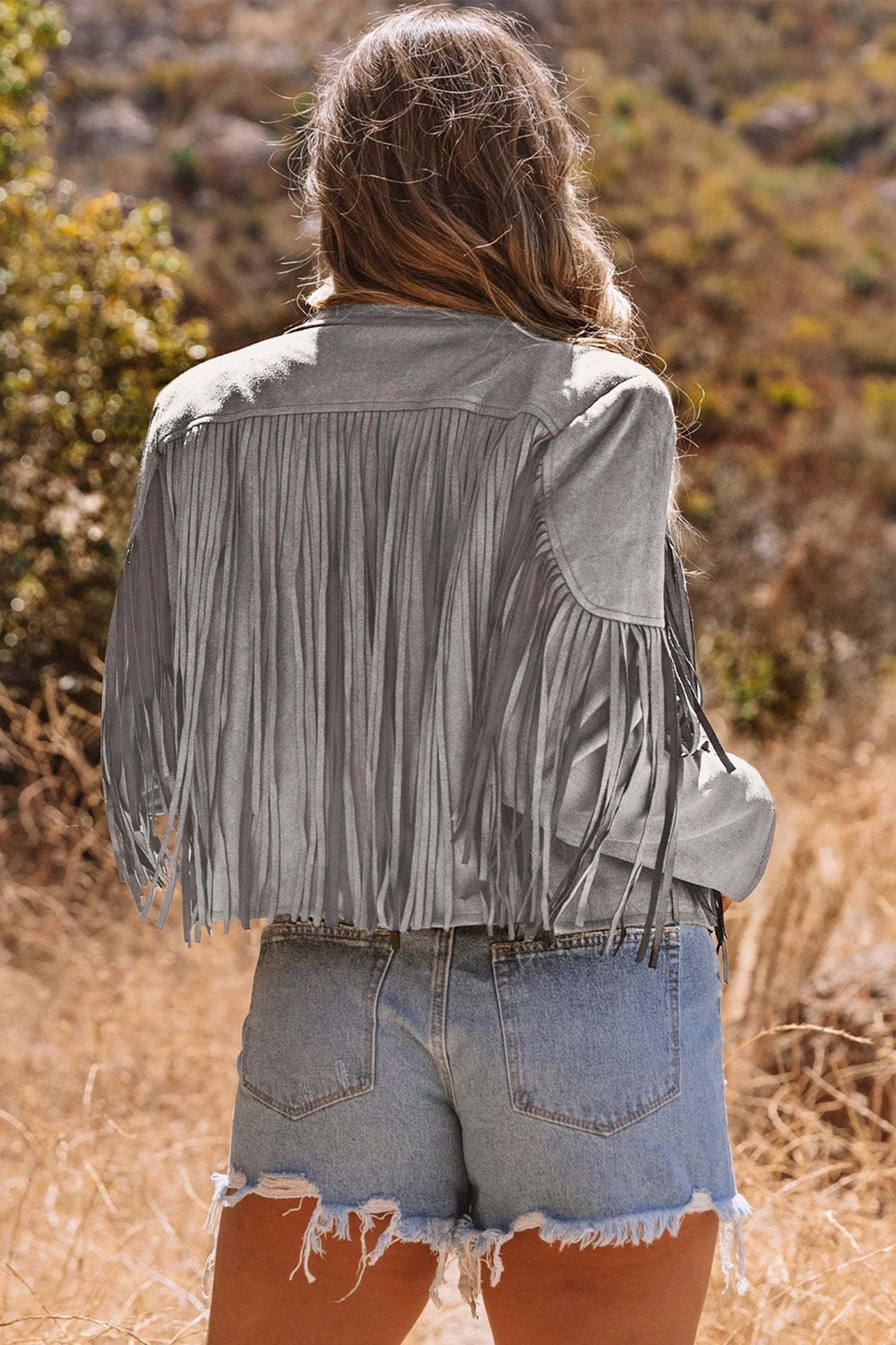 Woman wearing cropped fringe faux suede western jacket embodying main character energy