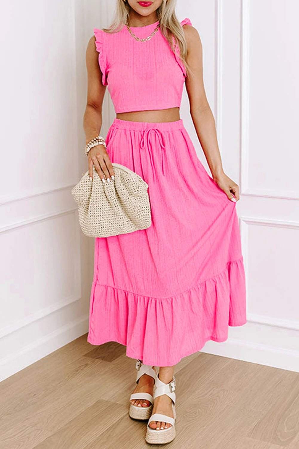 Woman wearing Boho Glow textured ruffle crop vest and lace-up maxi skirt set in vibrant pink