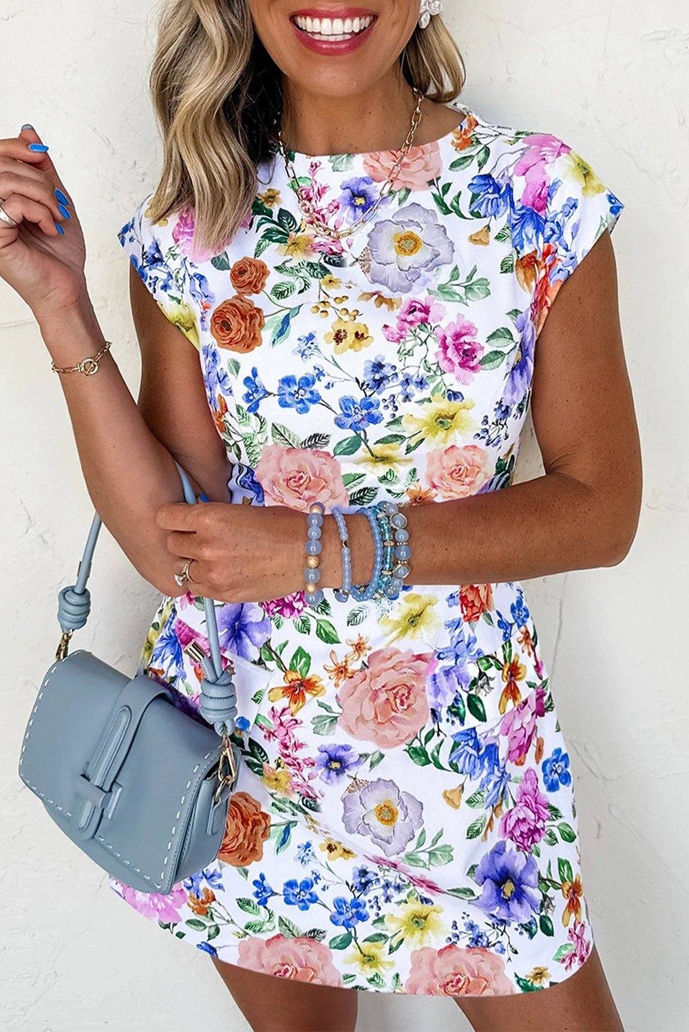 Woman wearing Confidence In Bloom floral print cap sleeve mini dress outdoors