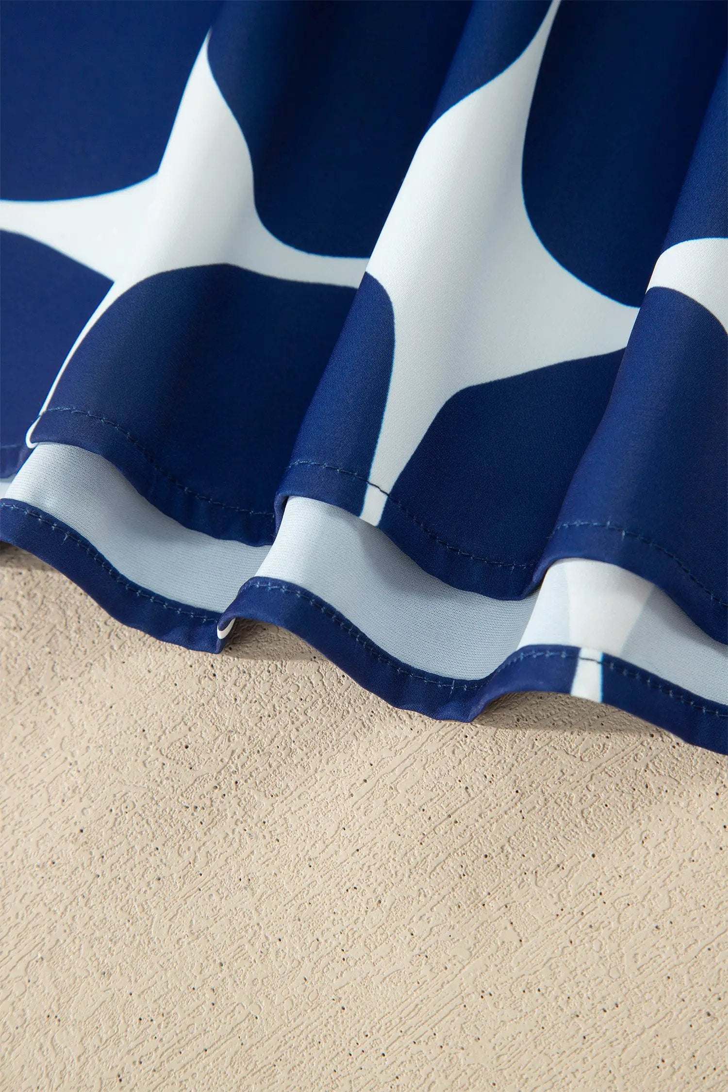 Blue and white polka dot tank top with frilled round neckline and sleeveless design