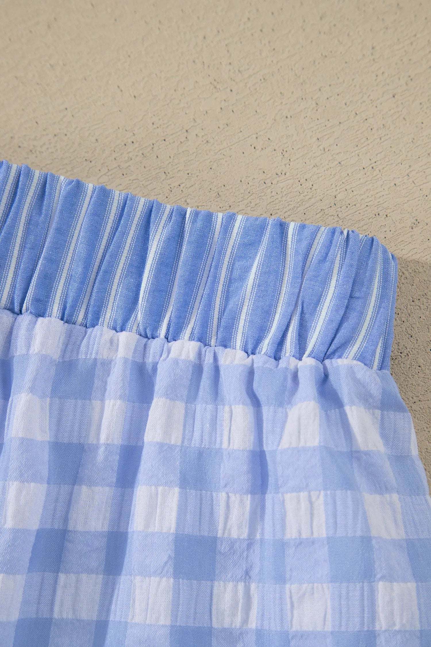 Woman wearing gingham ruffle hem shorts with lace tie waist on weekend outing