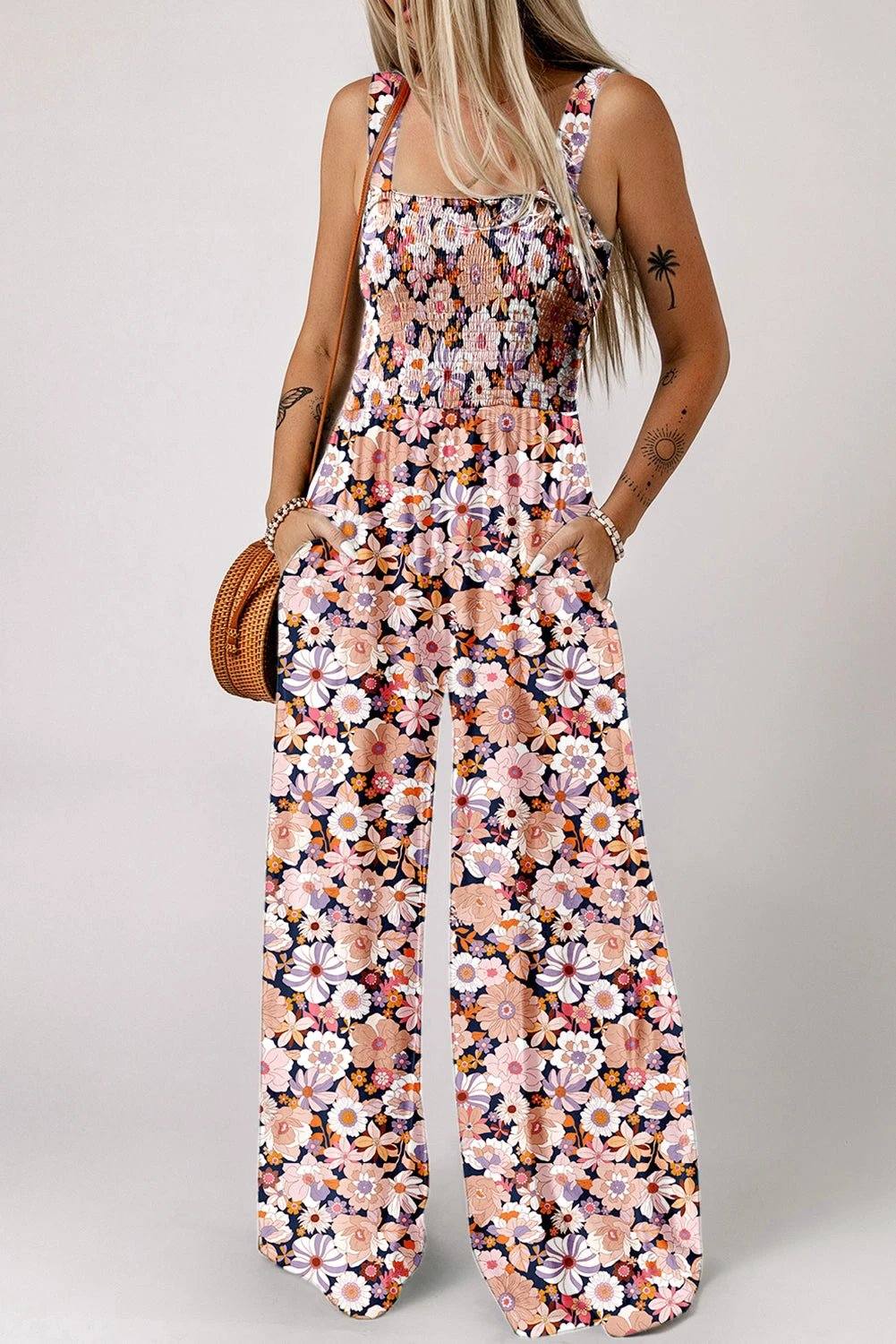 Woman wearing a boho chic floral smocked square-neck jumpsuit with wide-leg silhouette