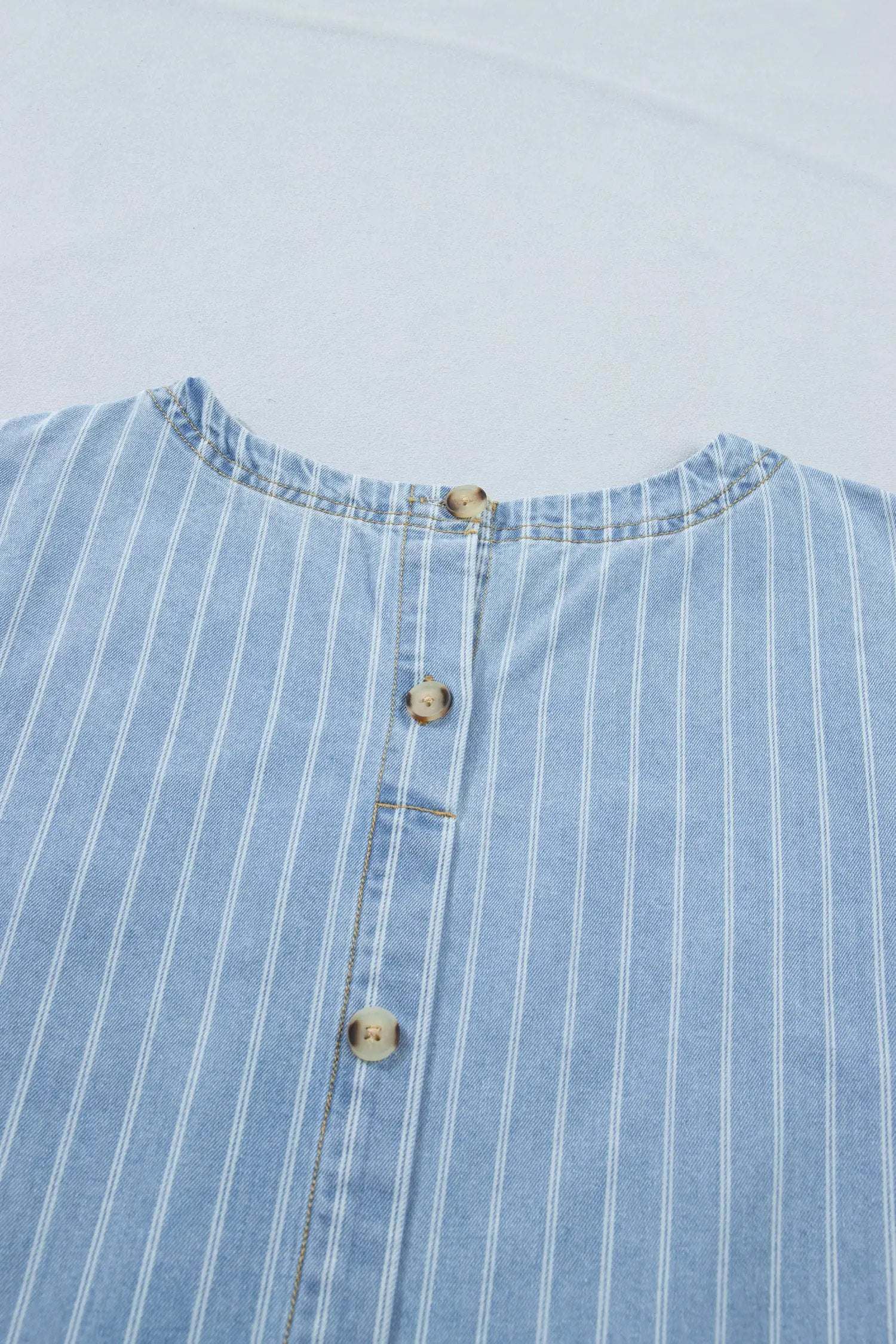 Woman wearing stripe denim mini dress with buttoned back in casual setting