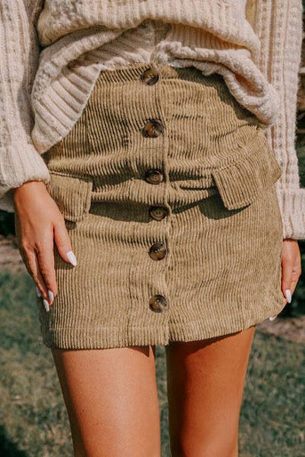 Woman wearing a stylish corduroy buttoned front mini skirt with faux pockets