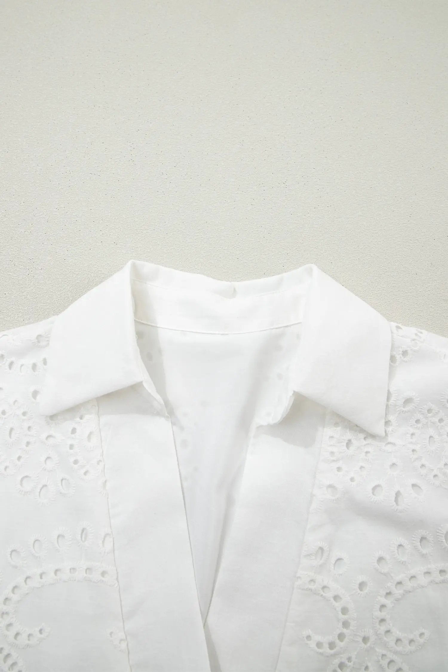 Woman wearing white solid color eyelet embroidered T shirt mini dress outdoors