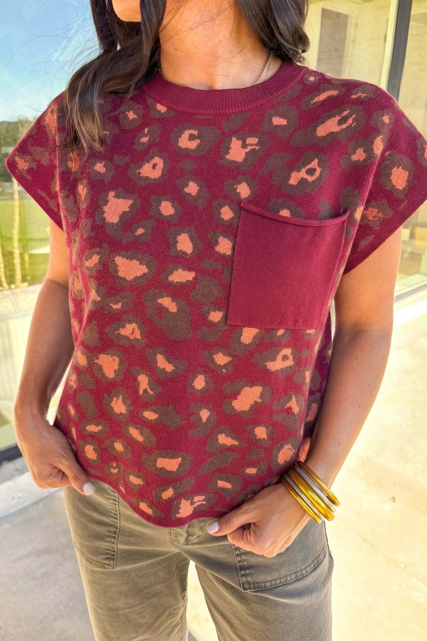 Woman wearing leopard print cap sleeve knitted top with Western flair