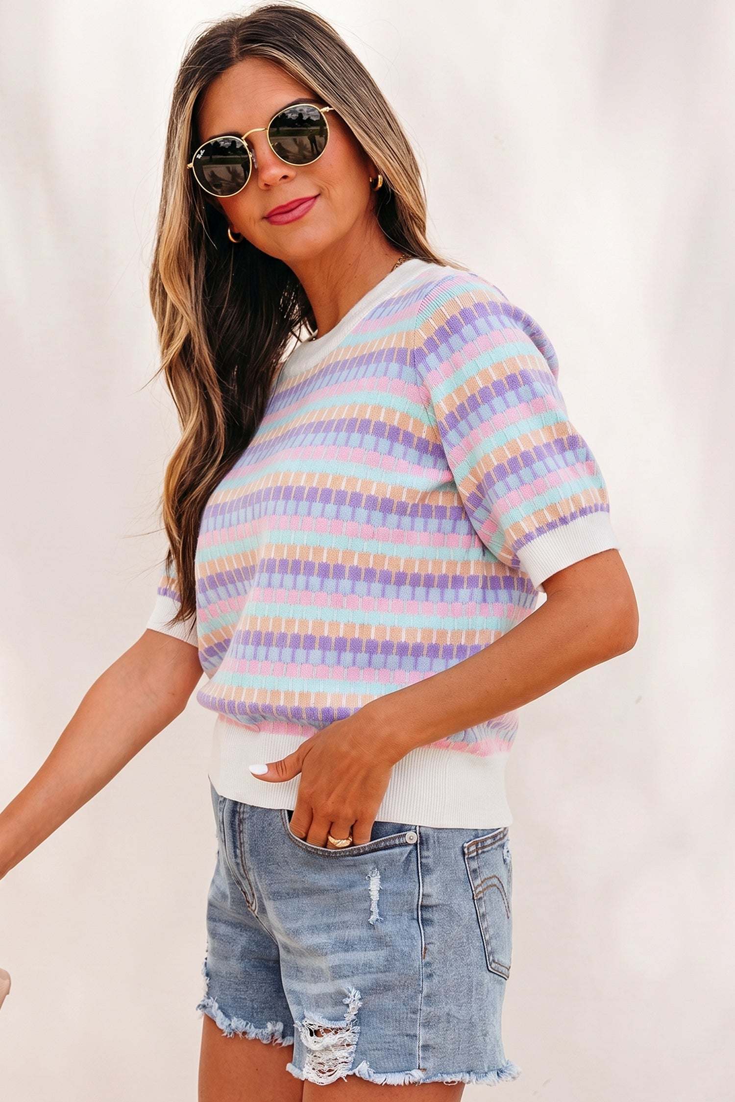Woman wearing orange striped knit sweater with abstract orange stripes and pink rib neckline