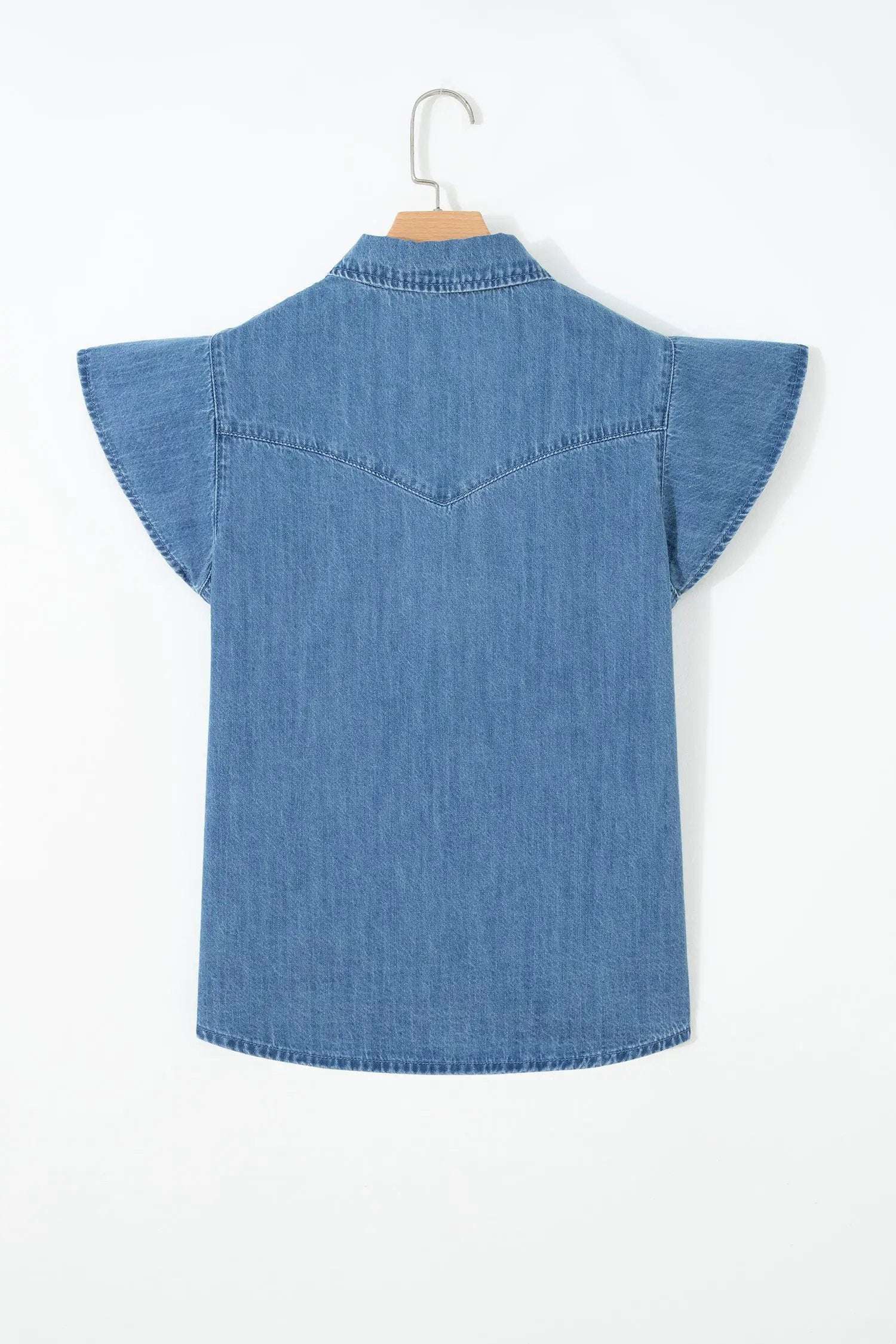 Woman wearing denim ruffled short sleeve shirt with button front and flutter sleeves