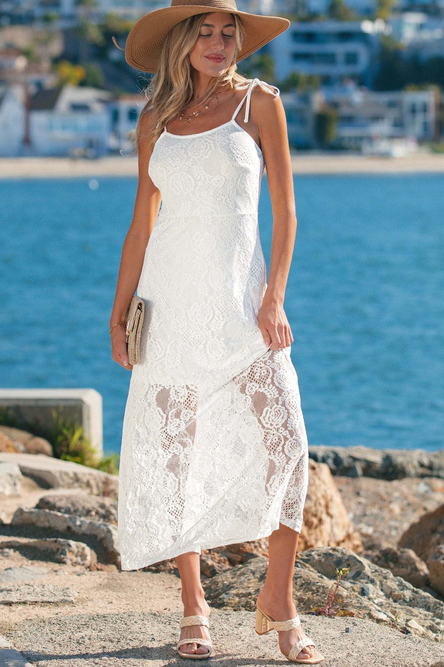 Woman wearing a floral lace overlay maxi dress with spaghetti straps and scalloped edges
