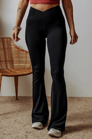 Woman wearing black V shape high waist flared leggings standing indoors with cozy mom energy