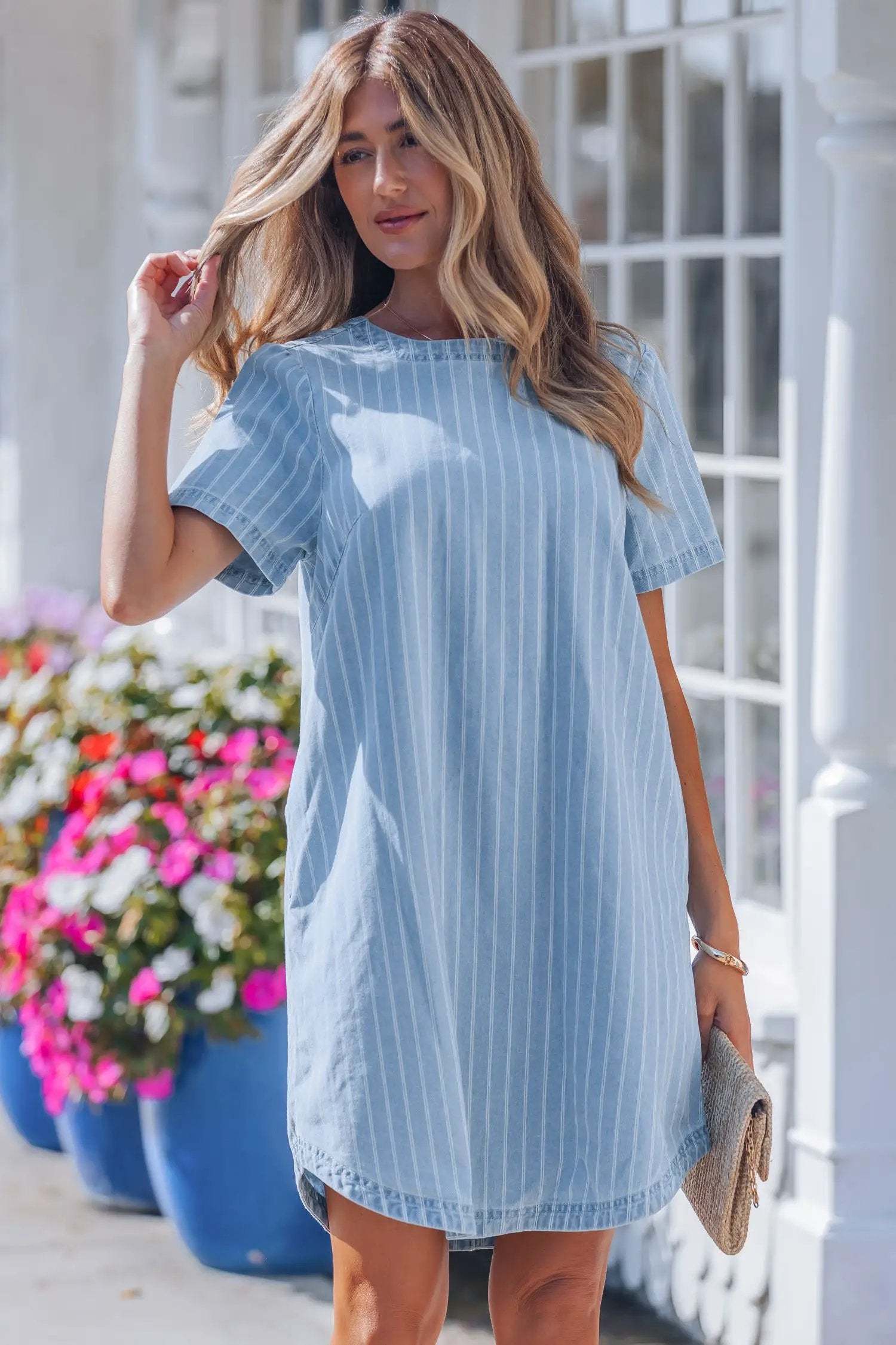 woman wearing stripe denim mini dress with buttoned back and vertical stripes