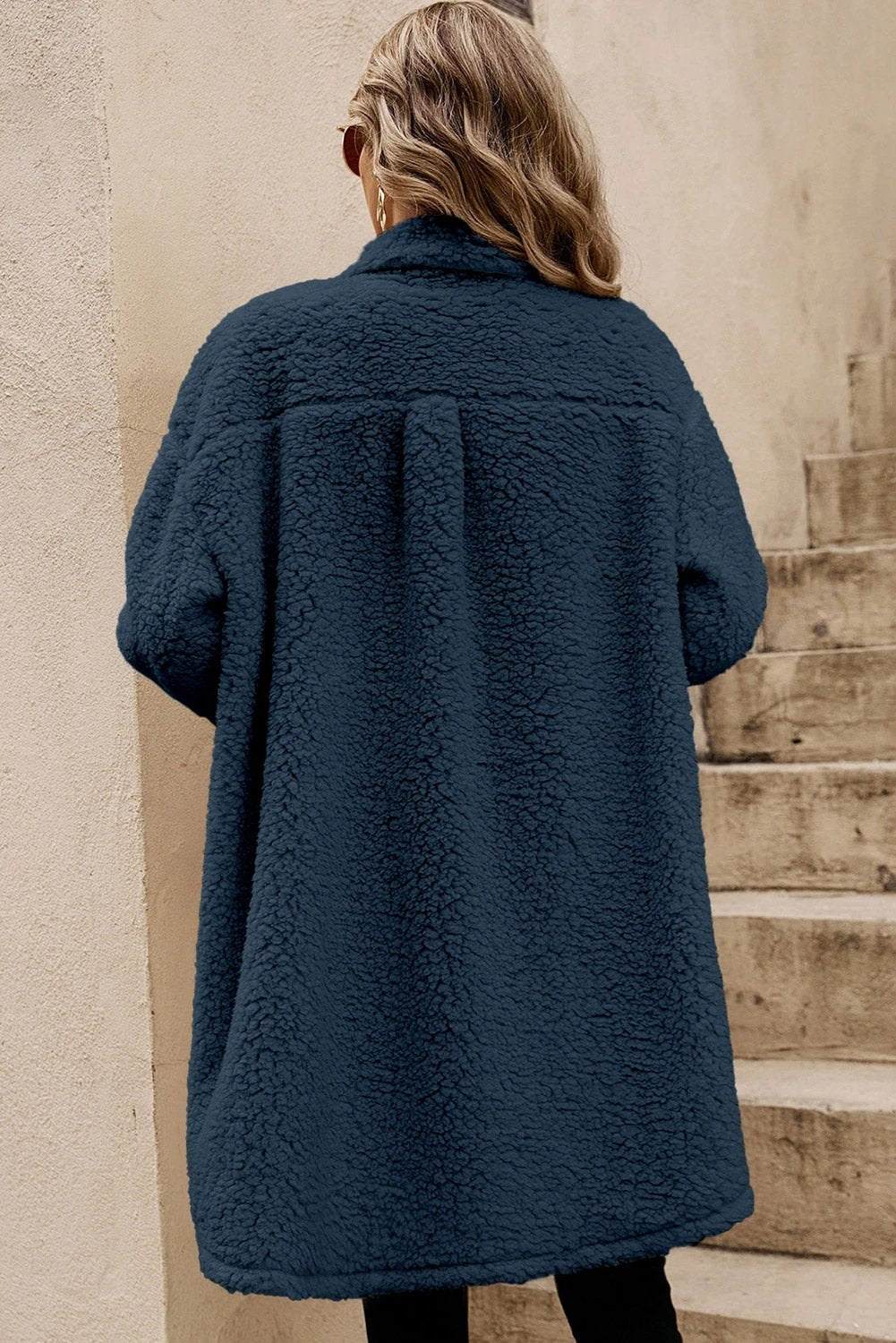 Woman wearing cozy teddy fleece coat with navy contrast flap pockets and single-breasted front