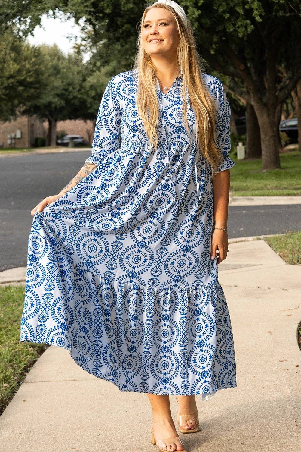 Plus size woman wearing blue and white geometric print maxi dress with lace-up notch neck standing outdoors