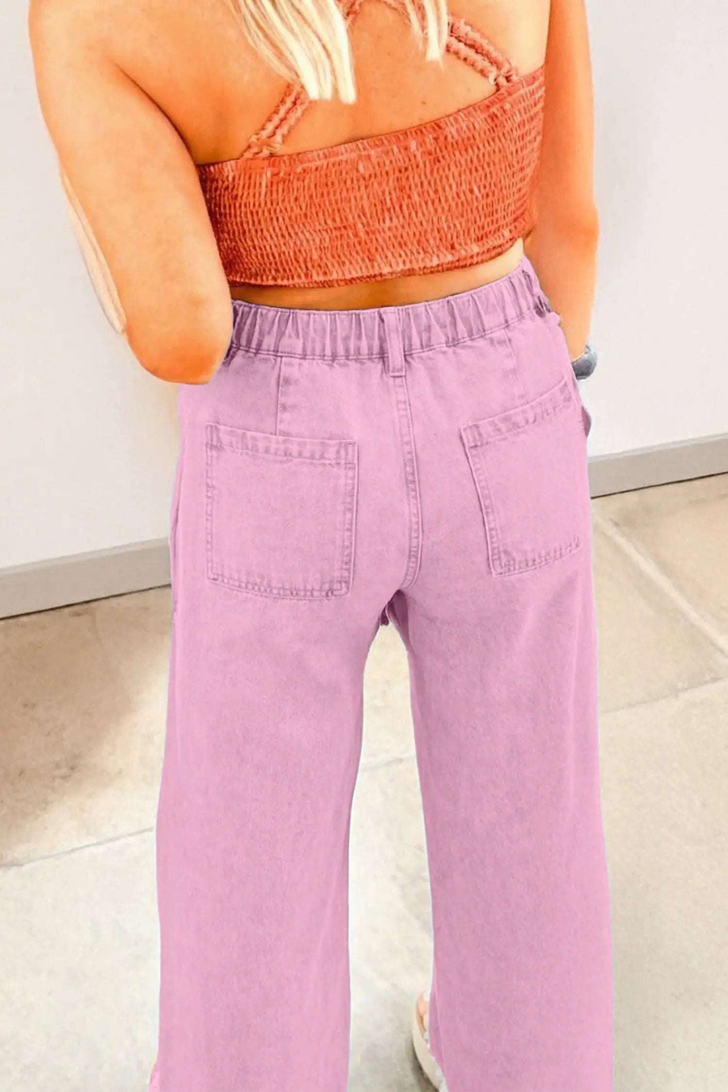 Pink high rise wide-leg jeans with beaded side detail and split hem on model