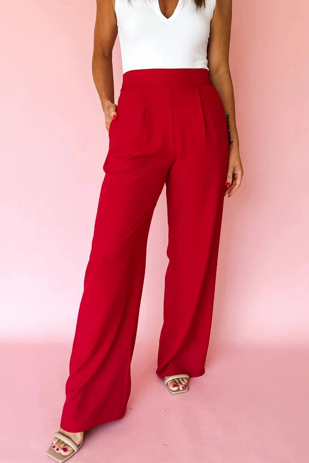 Woman wearing red pleated detail high waist loose straight pants with elastic waistband