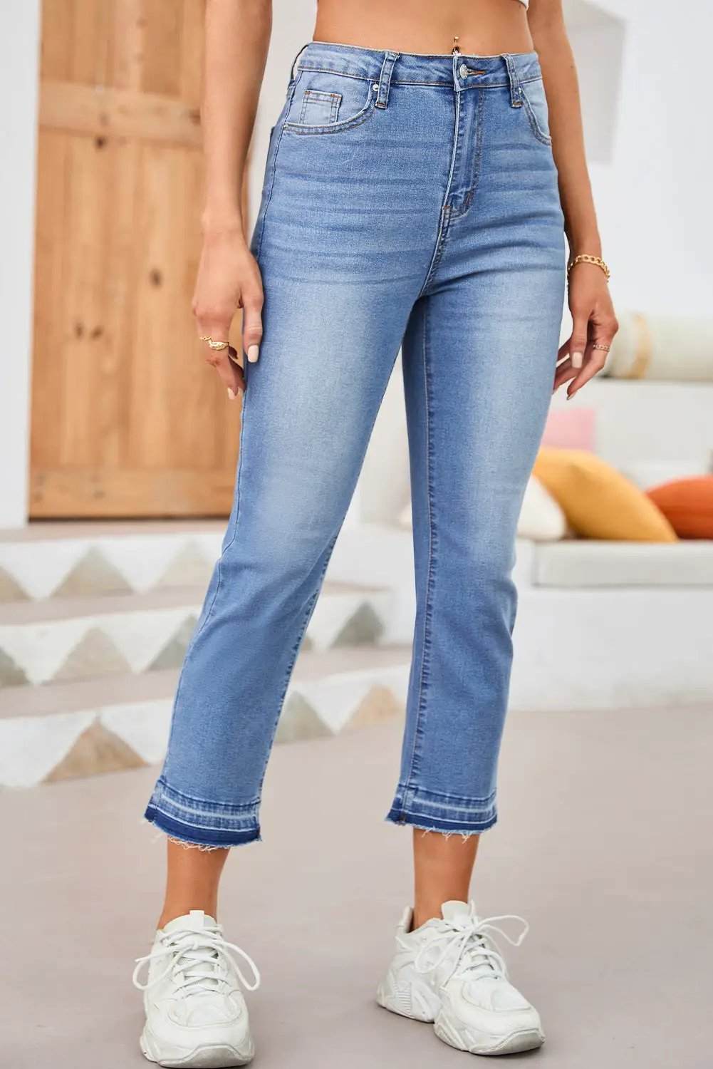 Woman wearing whiskered wash cropped jeans with raw hem showcasing main character energy style