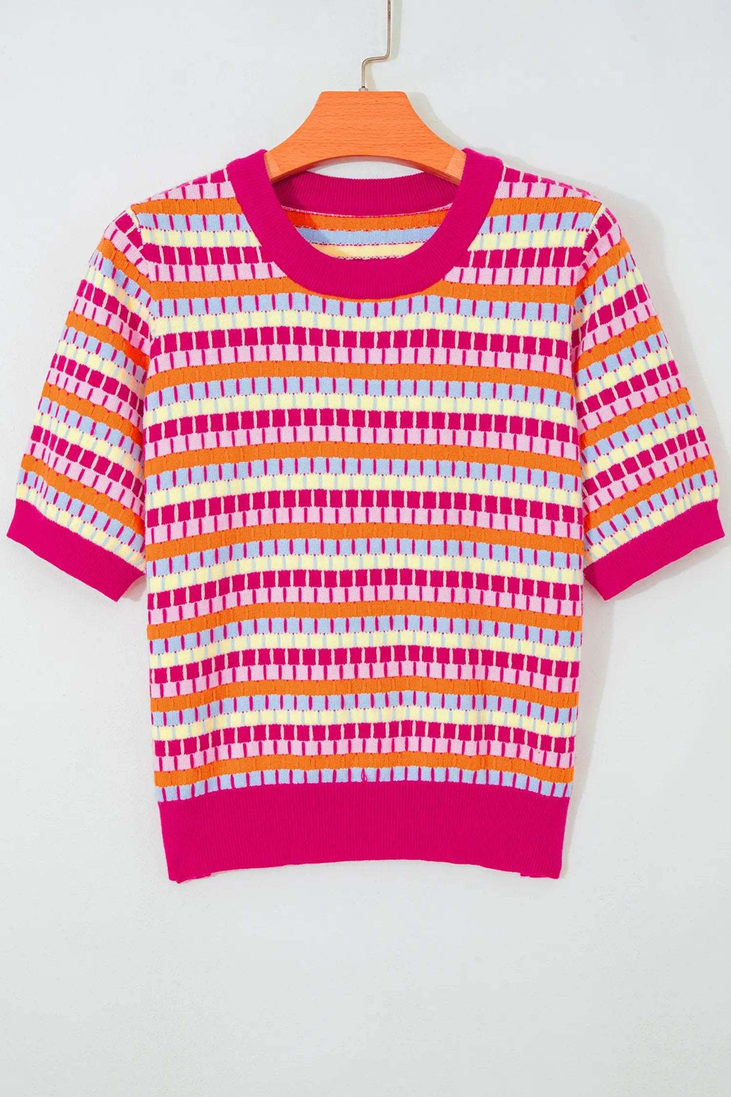 Woman wearing vibrant orange striped knit sweater with short sleeves and abstract stripes