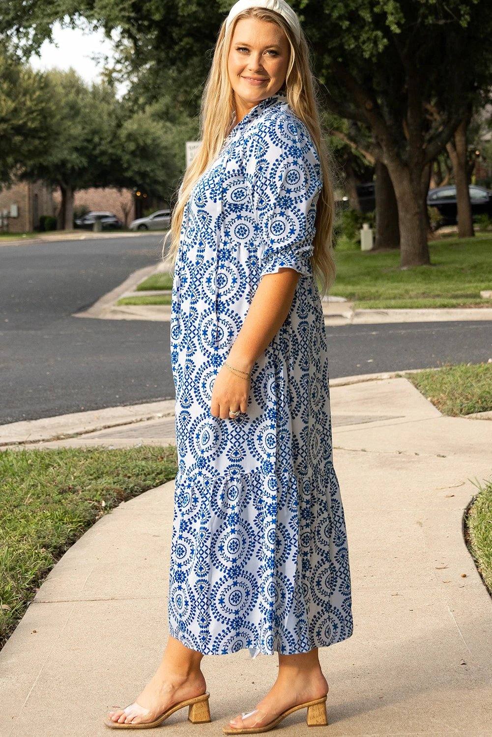 Plus size woman wearing blue and white geometric print maxi dress with lace-up notch neck