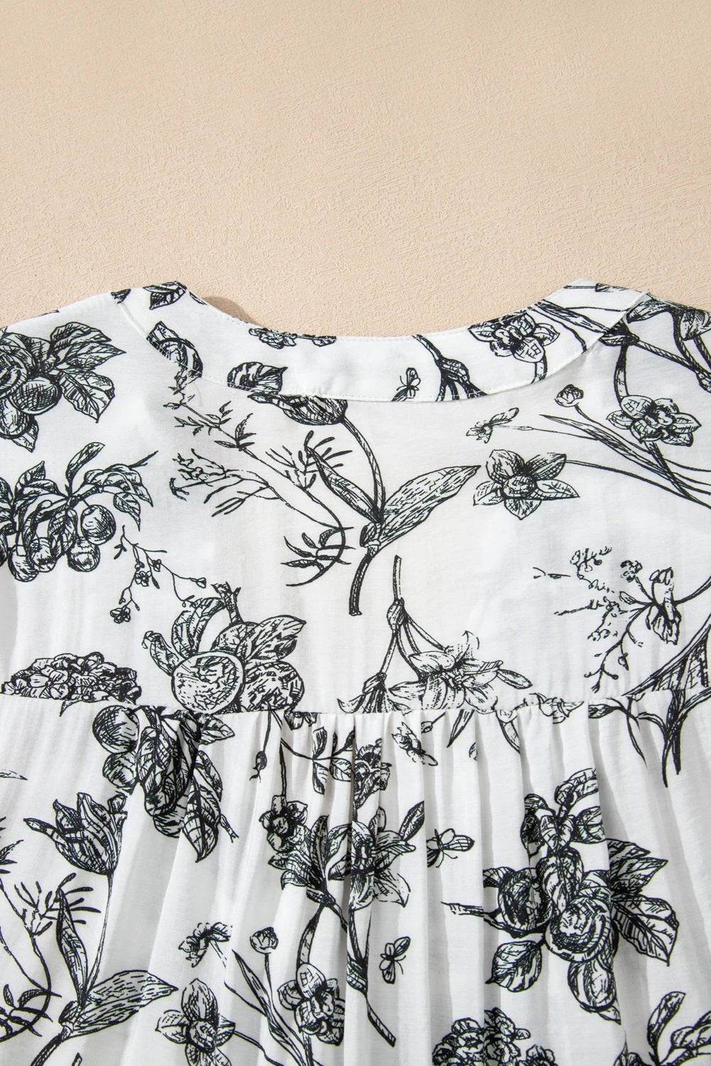 Plus size floral maxi dress with piping trim, notched neck, and ruffle sleeves on a model